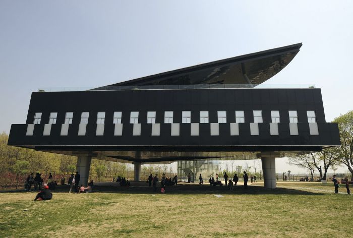 Visitors gather in front of and below a piano-shaped building in Huainan, Anhui province April 9, 2009. The building will be used as the Urban Planning Exhibition Hall.  REUTERS/Jianan Yu (CHINA ENTERTAINMENT SOCIETY)