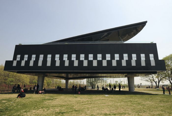 Visitors gather in front of and below a piano-shaped building in Huainan, Anhui province April 9, 2009. The building will be used as the Urban Planning Exhibition Hall. REUTERS/Jianan Yu (CHINA ENTERTAINMENT SOCIETY)